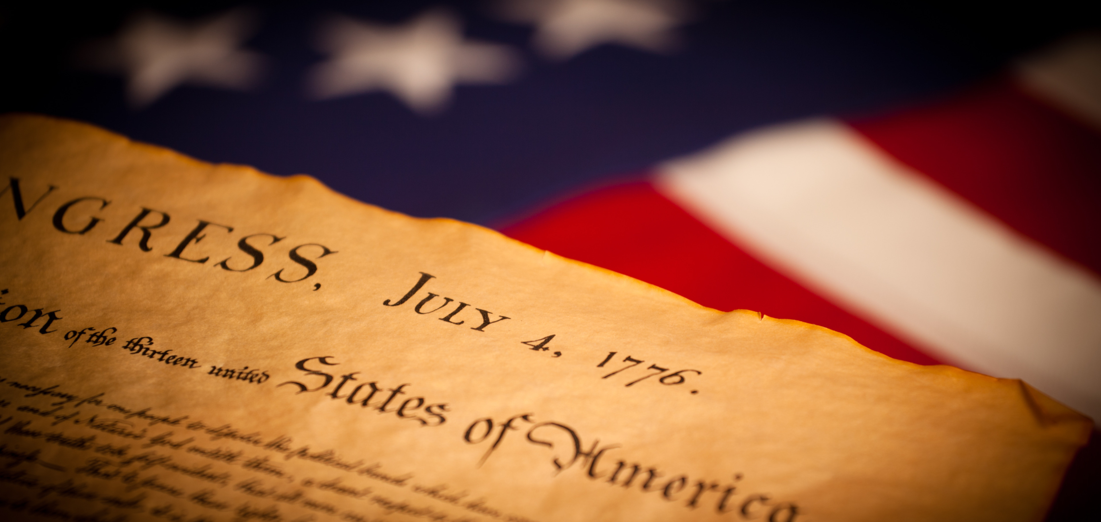 La Declaración de Independencia, fechada el 4 de julio de 1776, junto a una bandera estadounidense.