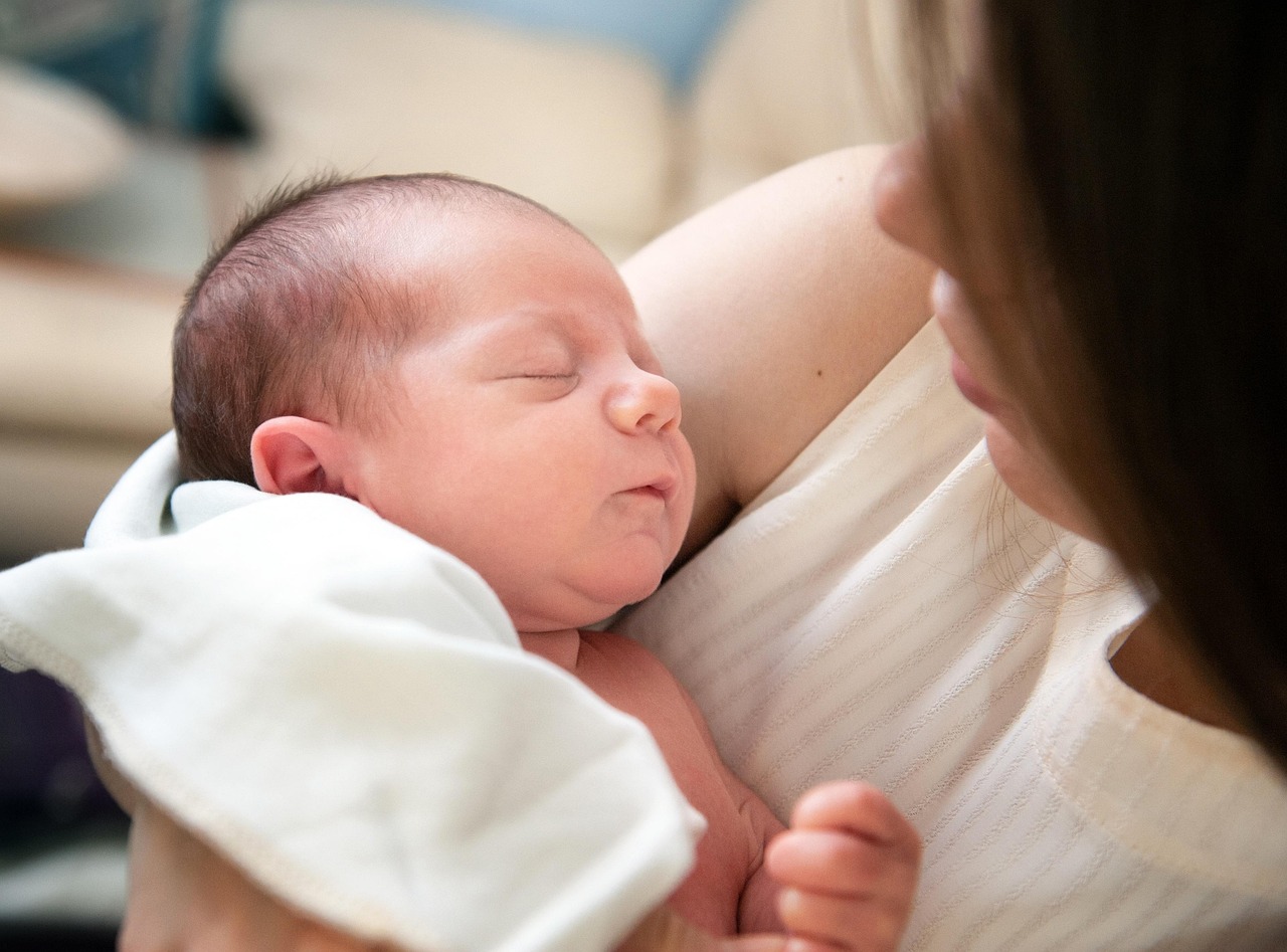A parent holding a sleeping newborn