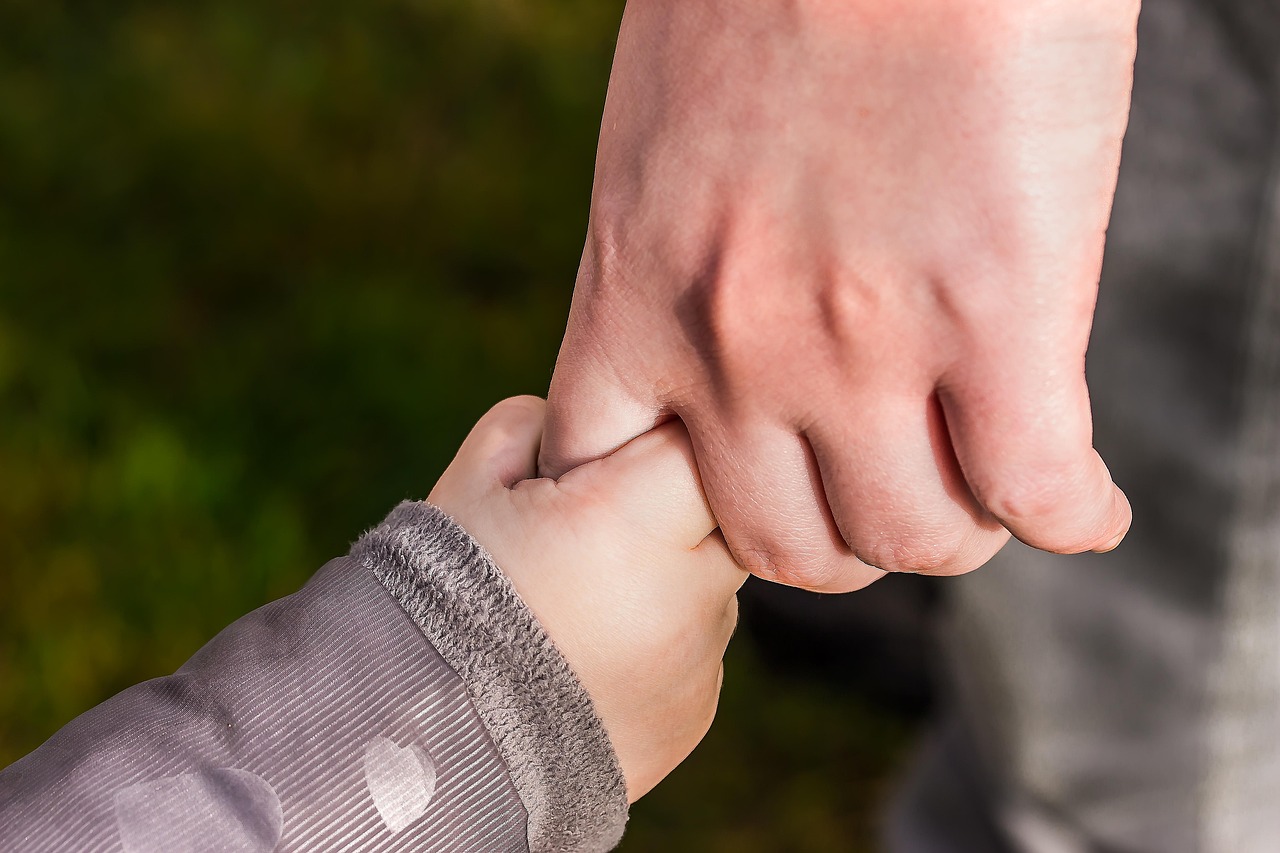 A child holding an adult’s hand